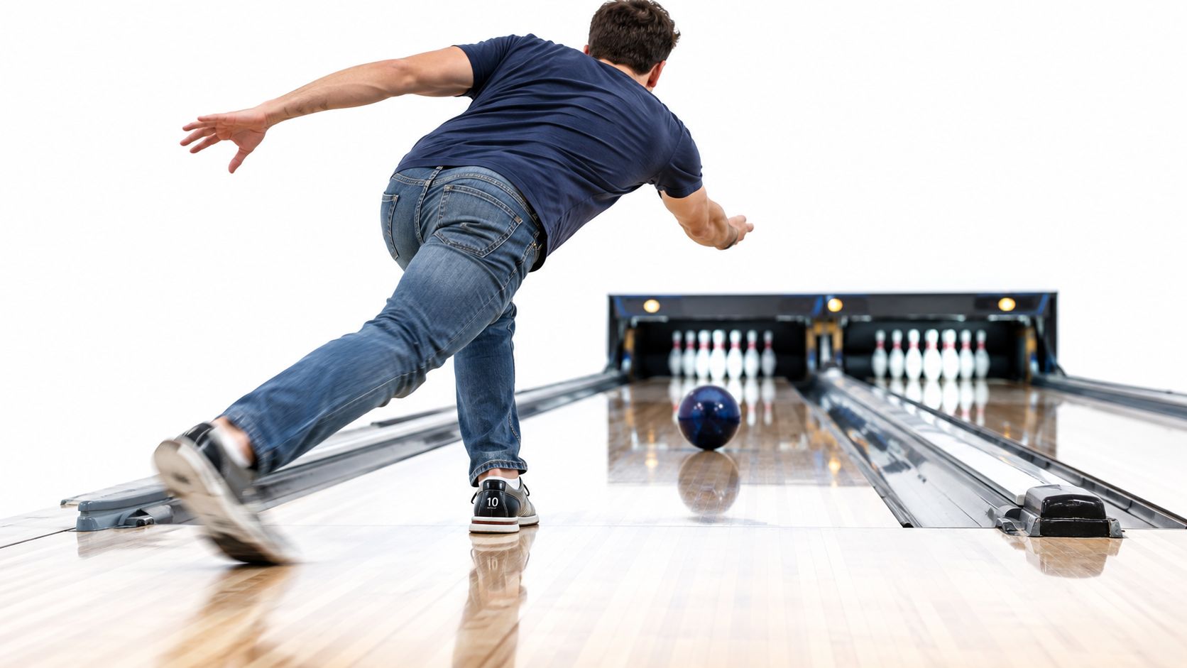 A person wearing specialized bowling shoes bowling a dark blue ball down a professional lane